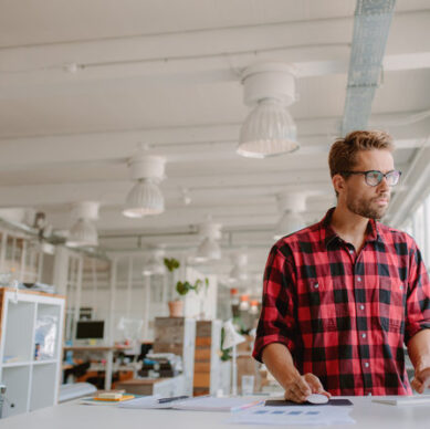 Shot of young businessman in casual clothes at modern startup business office space, working on  desktop computer.
